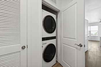 a washer and dryer combo in a white laundry room